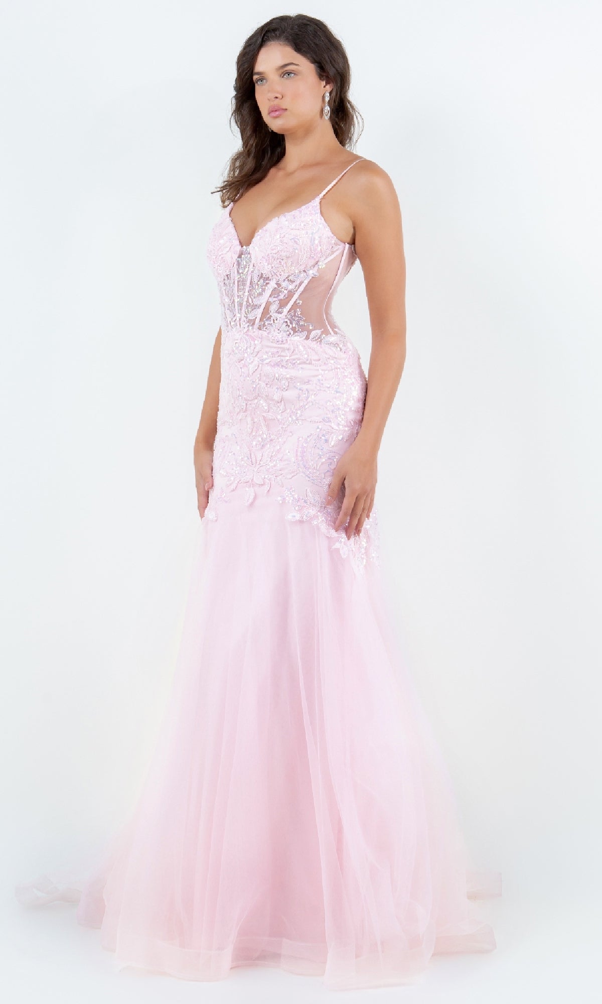 A woman poses against a white background wearing the Cinderella Couture 8276J, a light pink, floor-length mermaid prom dress featuring lace details and sheer side panels.